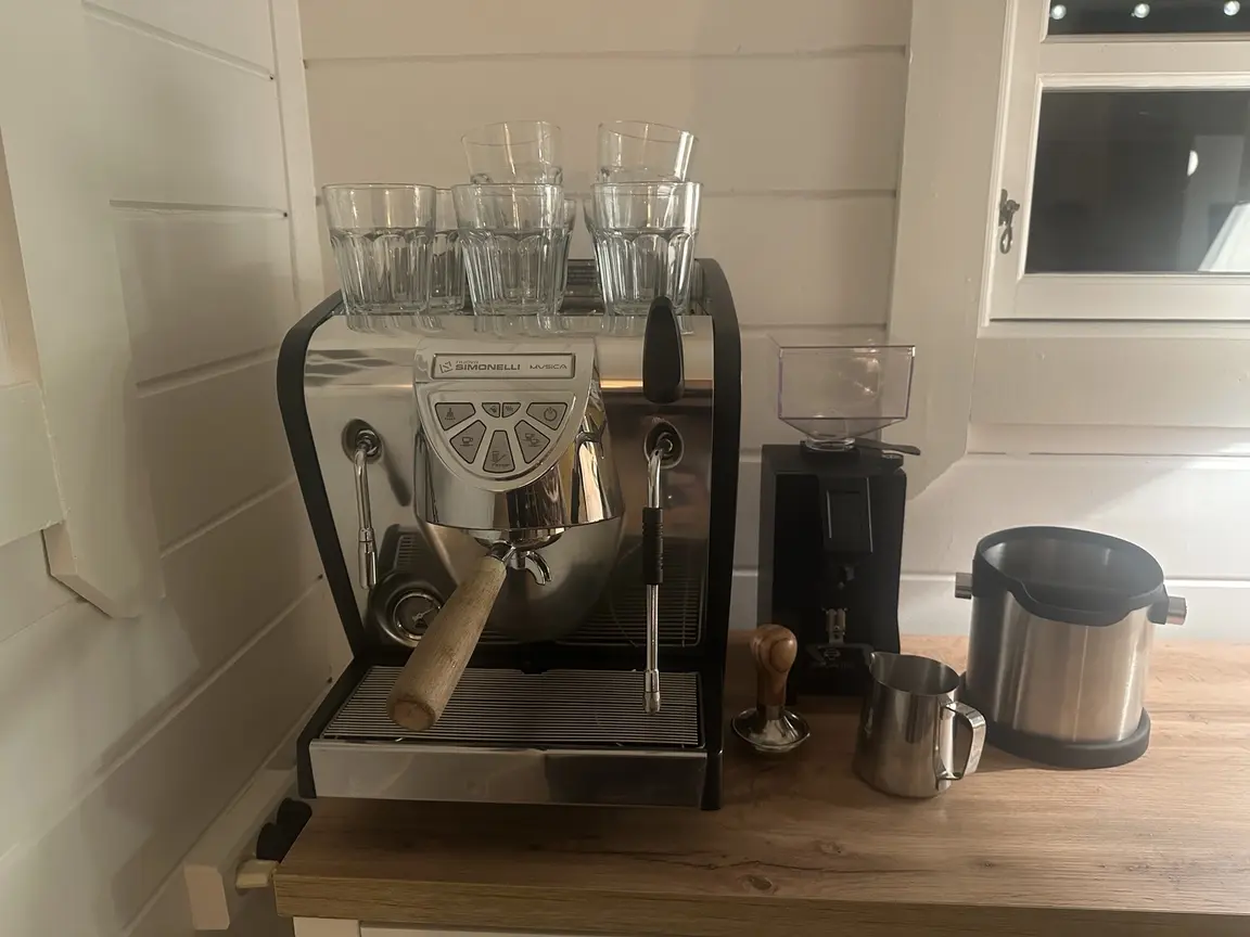 Nuova Simonelli Musica espresso machine beside a Eureka Mignon Specialità grinder in the Brew Uncut summer-house setup